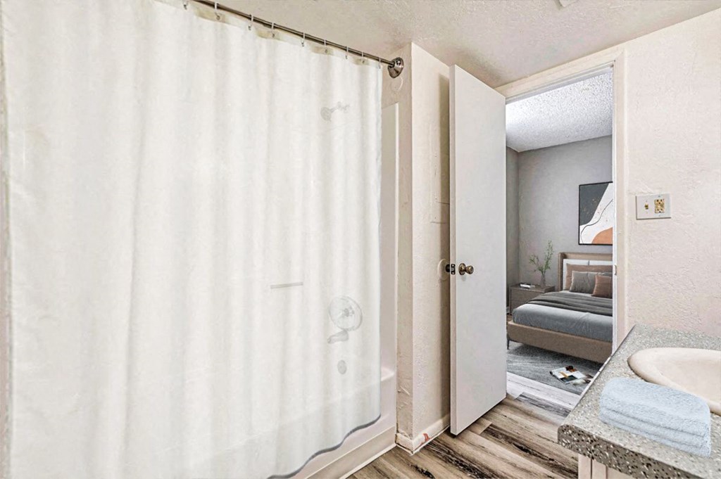 A bathroom with a white shower curtain and a white sink.