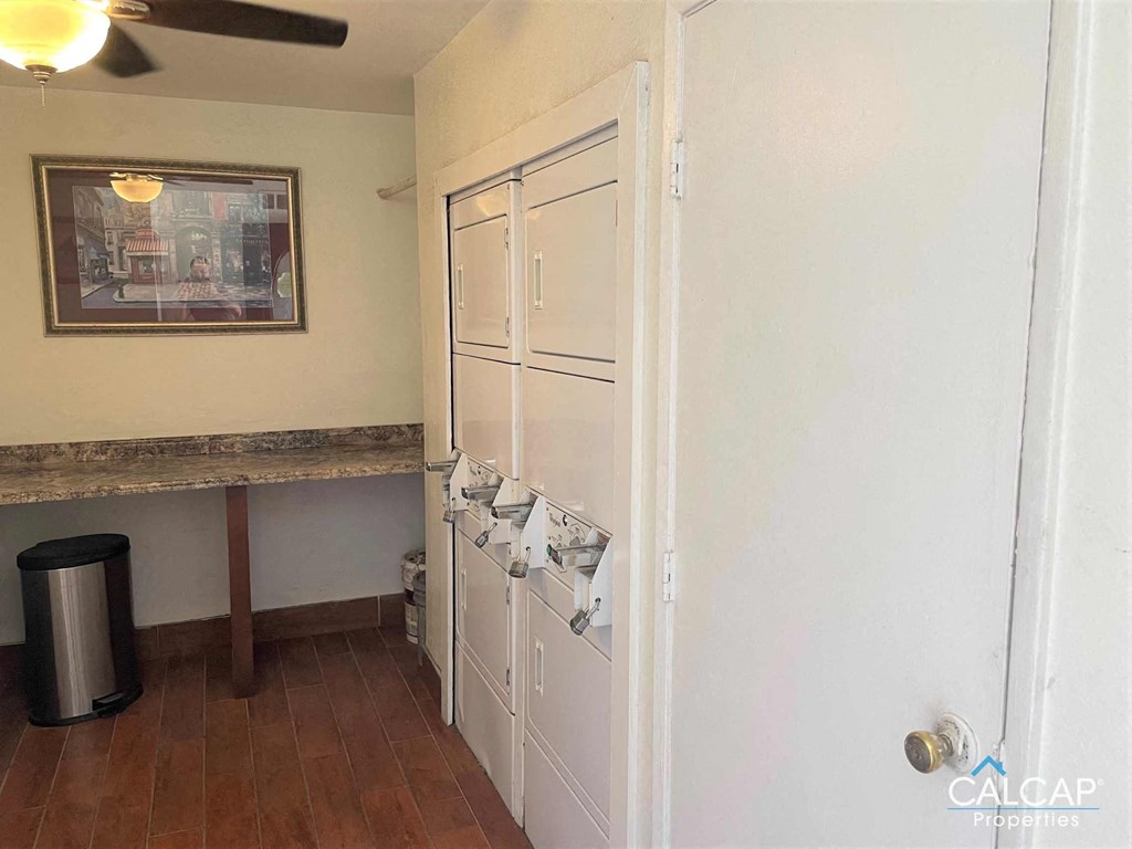 A room with a white door, a brown table, and a framed picture on the wall.
