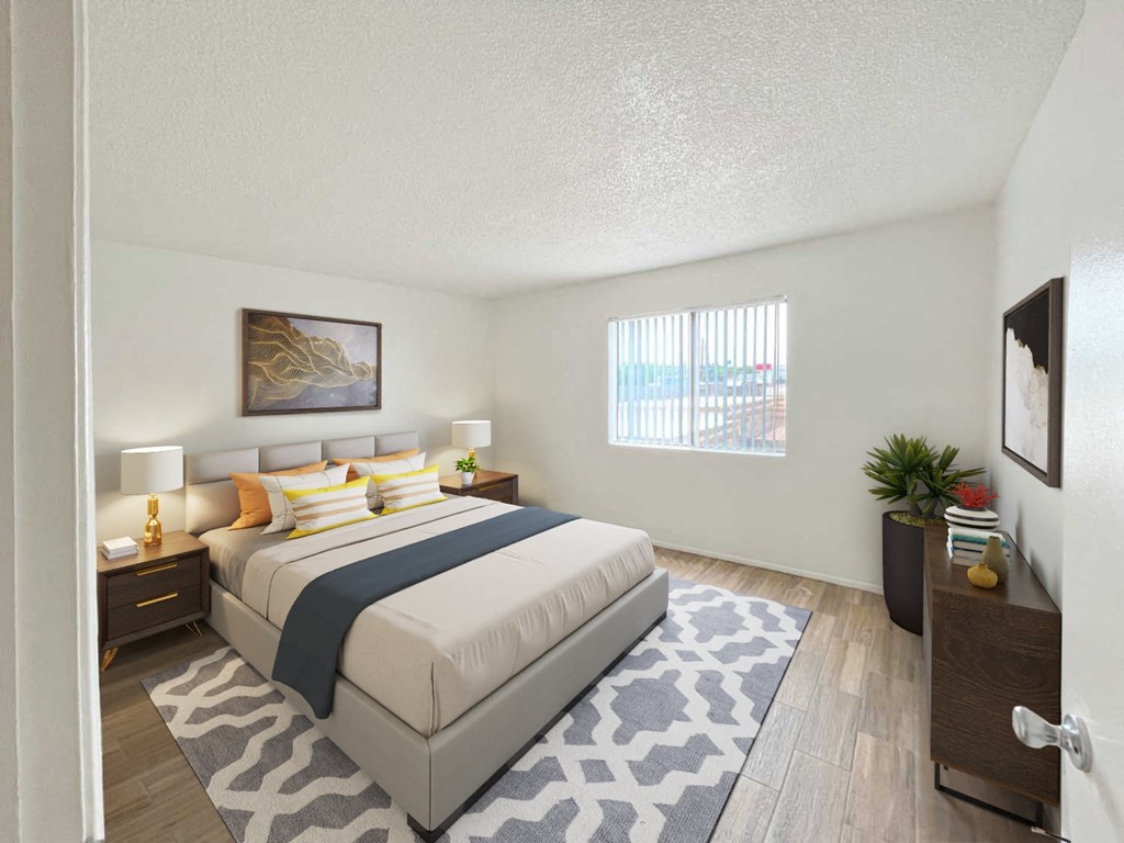 A bedroom with a large bed and a window with blinds.
