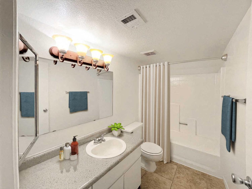 A bathroom with a sink, toilet, and shower.