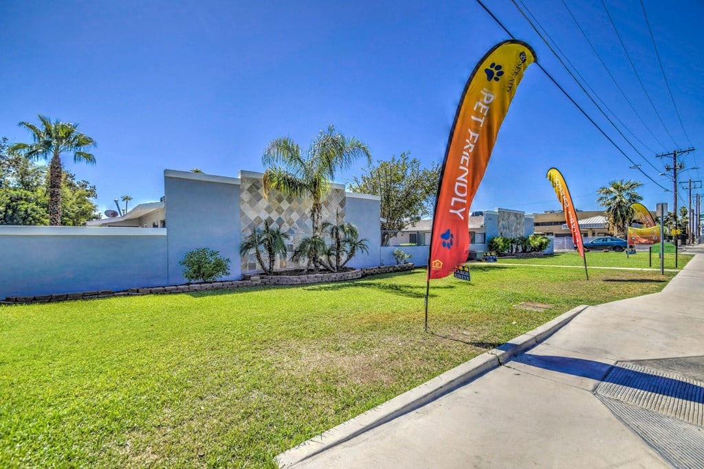 A building with a white wall and a red banner with the word "PETFRIENDLY" on it.