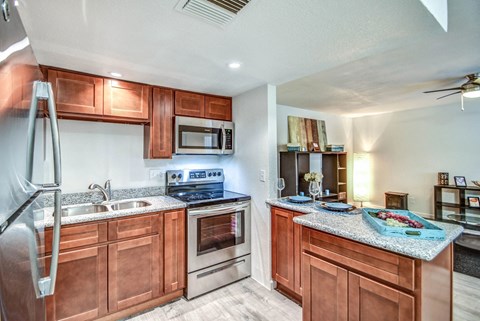 A kitchen with wooden cabinets and a granite countertop.