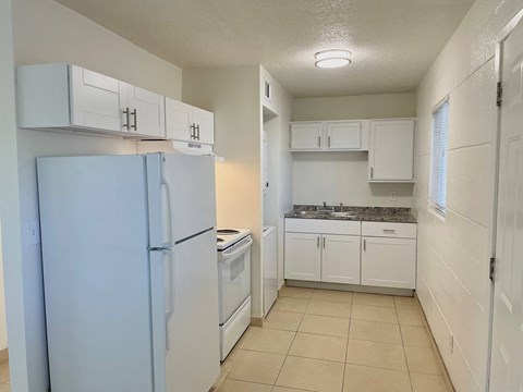 A kitchen with white cabinets and a blue fridge.
