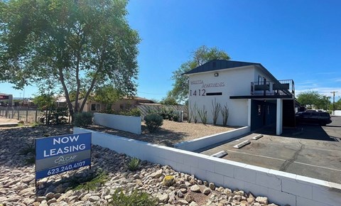 A sign in front of a building advertises that it is now leasing.