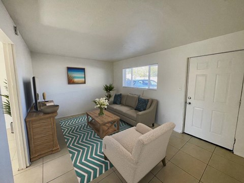 A living room with a couch, chair, and television.