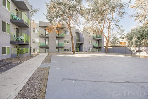 Apartment complex with green balconies and trees.