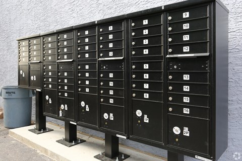 A row of black mailboxes with numbers on them.