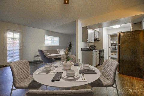 A dining room with a round table set for four.