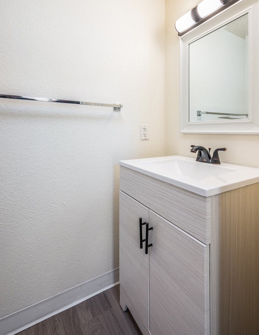 A bathroom with a white sink and a mirror above it.