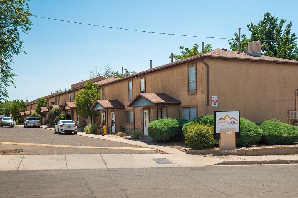 A street view of a residential area with houses and cars.