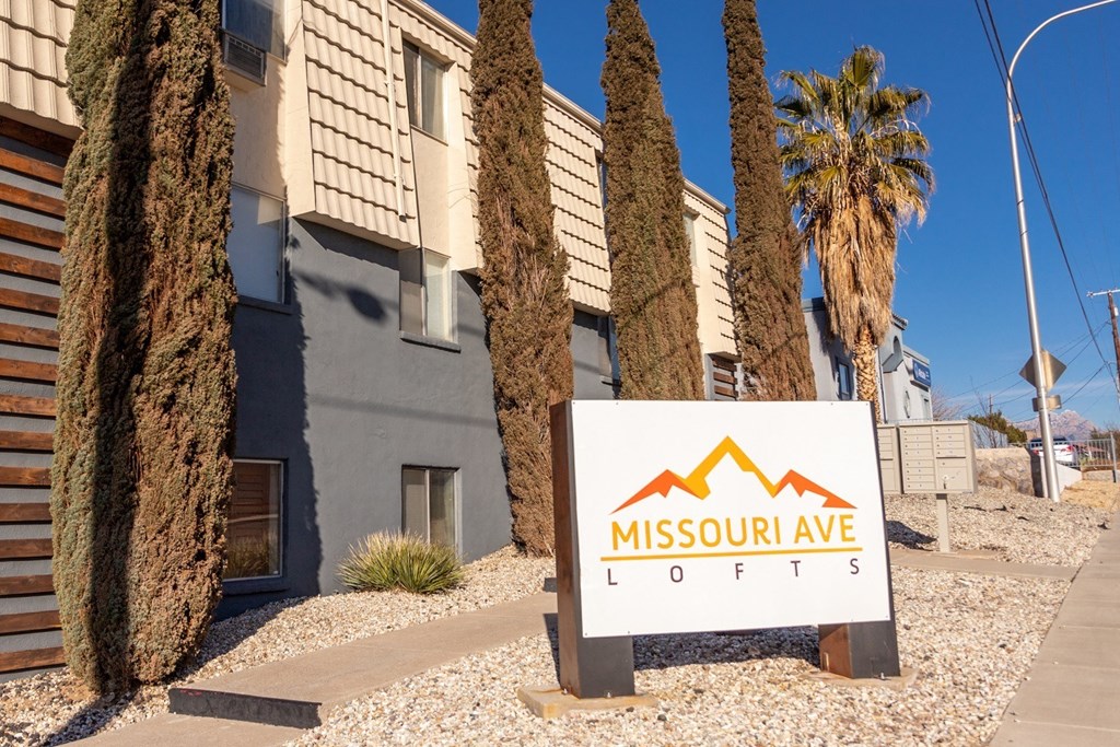 A sign for Missouri Ave Lofts is in front of a building and some trees.