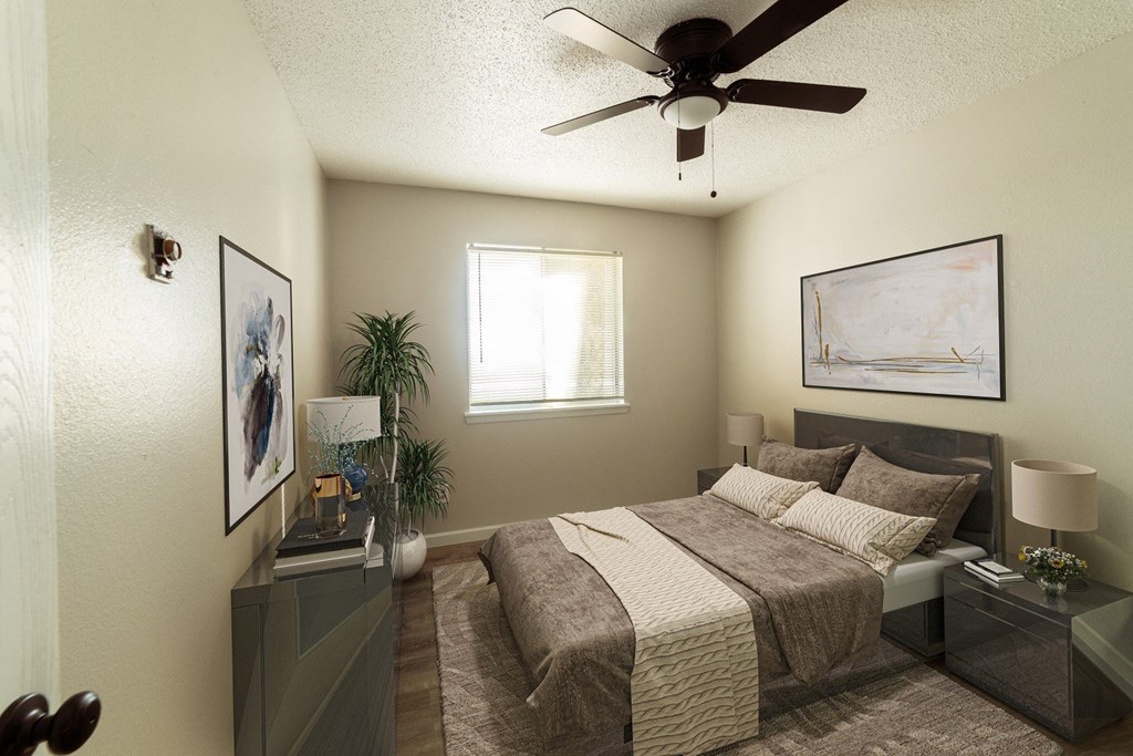 A bedroom with a bed, nightstands, and a ceiling fan.