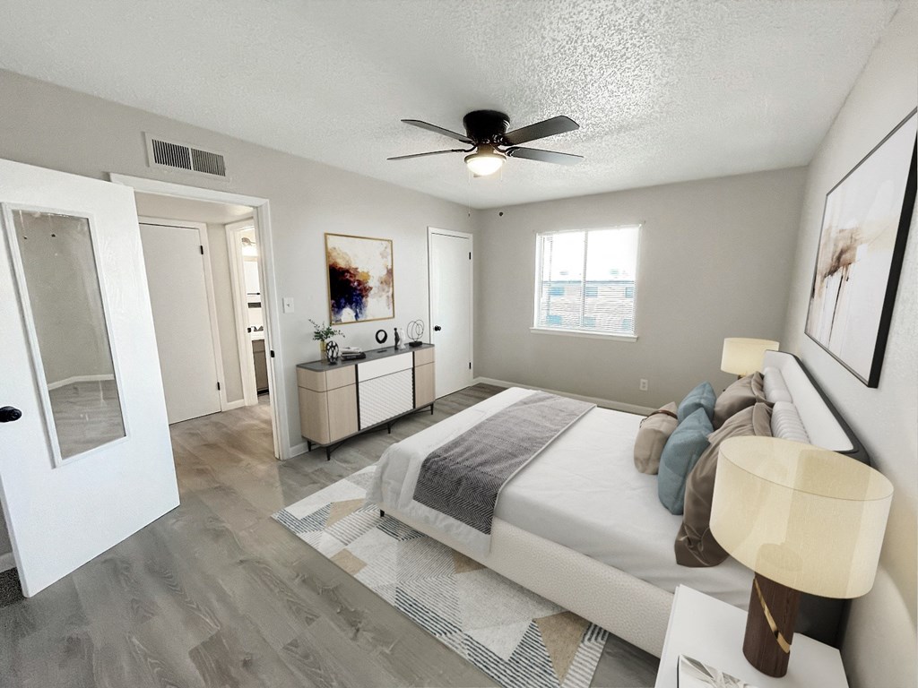 A bedroom with a bed, dresser, and ceiling fan.