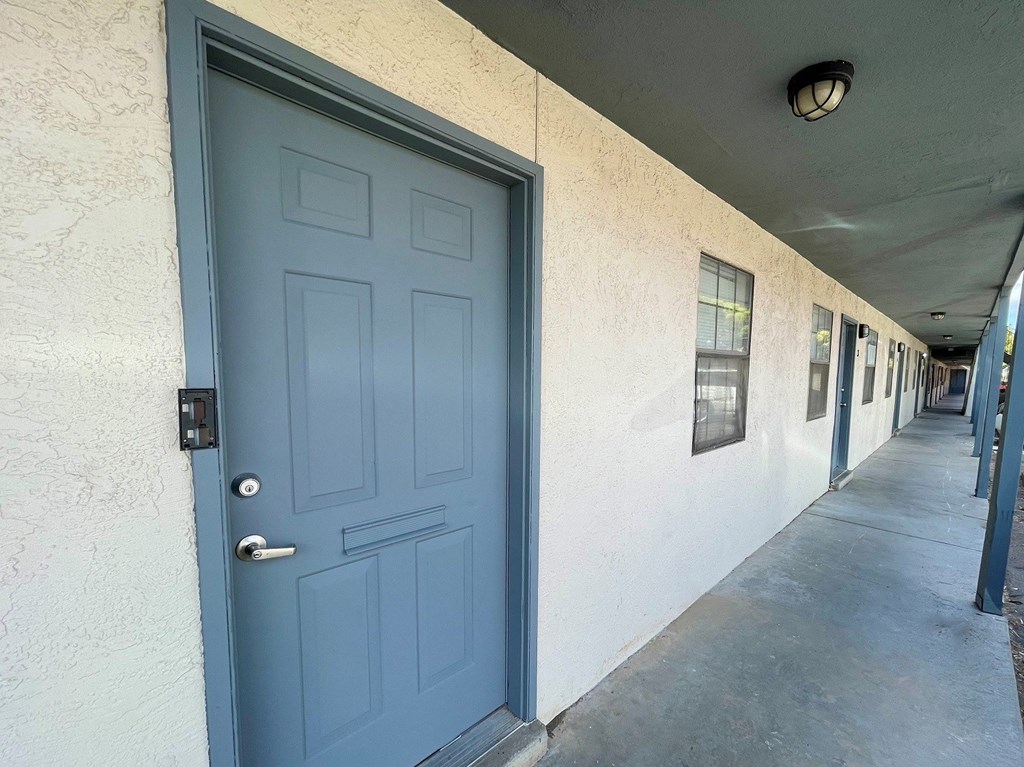 A blue door is on the left side of a white wall.