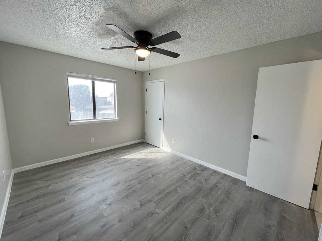 A room with a ceiling fan and a window.