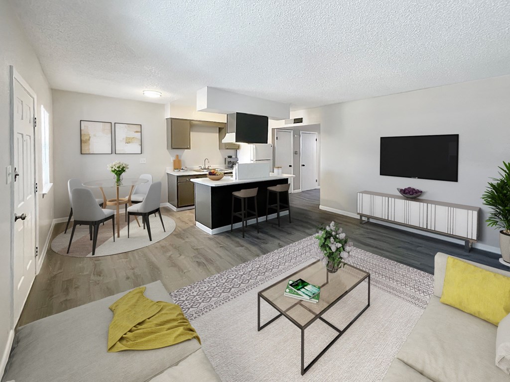 A living room with a white couch, a coffee table, and a television.