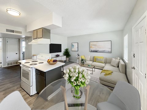 A modern kitchen with a dining table set with a vase of flowers.