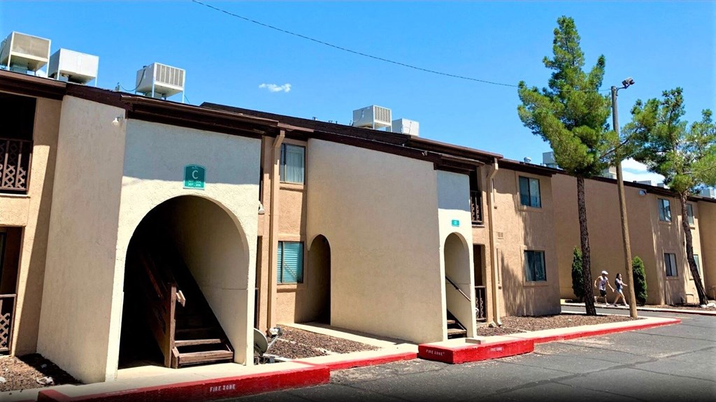 A row of beige buildings with arched doorways and windows.