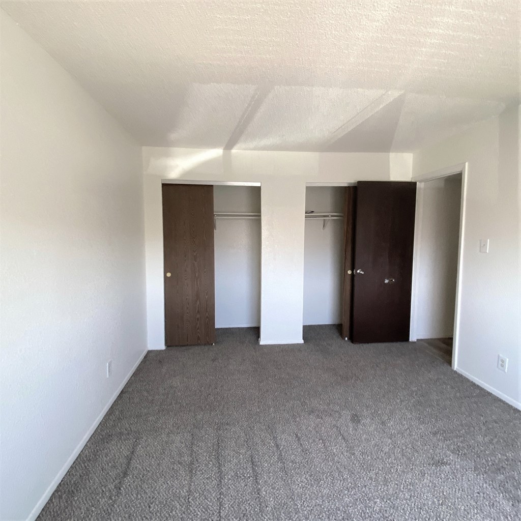 A room with two doors and carpeted floor.