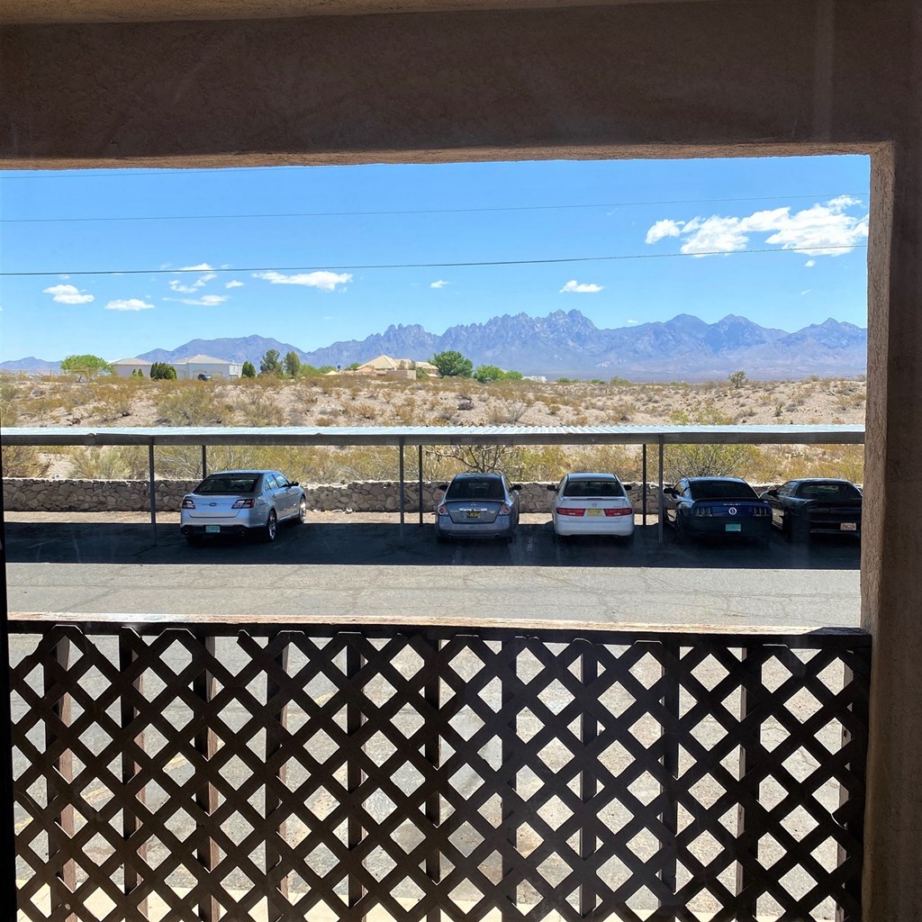 A parking lot with cars and a mountain range in the background.