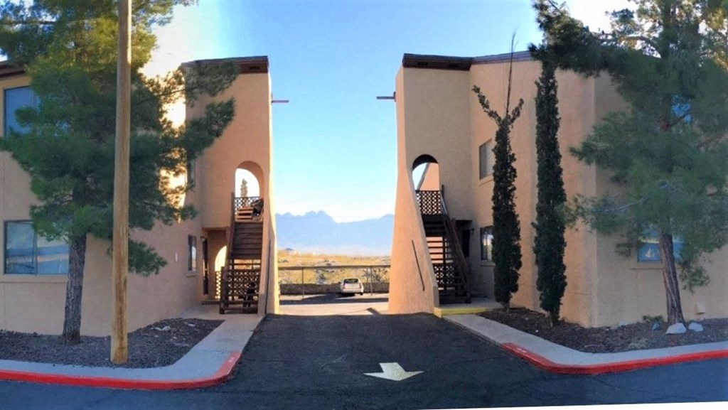 A building with a red arrow painted on the pavement in front of it.