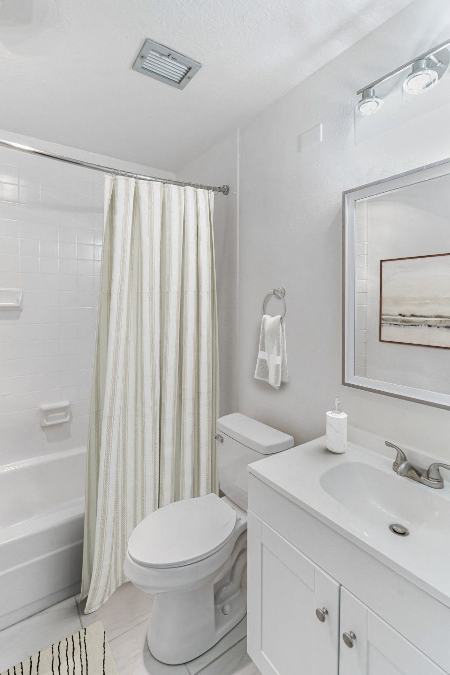 A white bathroom with a toilet, sink, and shower.