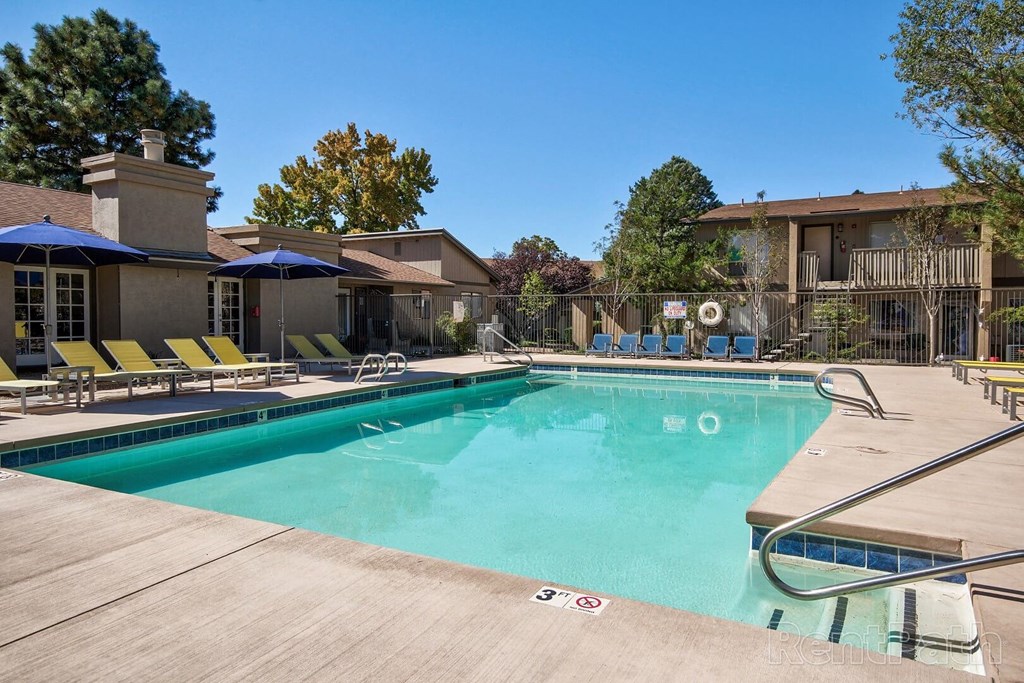 A large swimming pool with a slide and sun loungers.