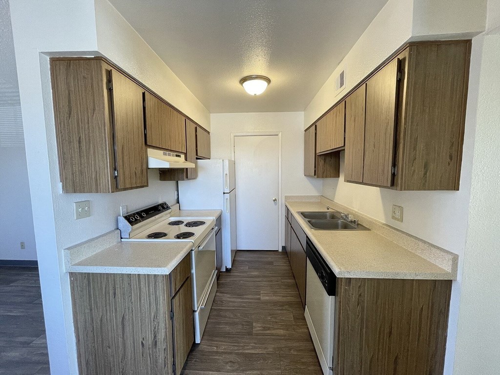 A kitchen with wooden cabinets and a white stove top oven.