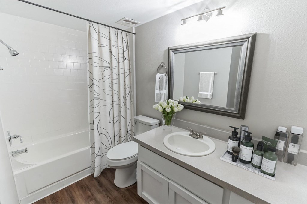 A white bathroom with a toilet, sink, and shower.