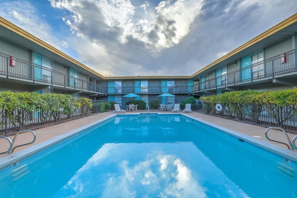 A large swimming pool in the middle of a building surrounded by balconies.