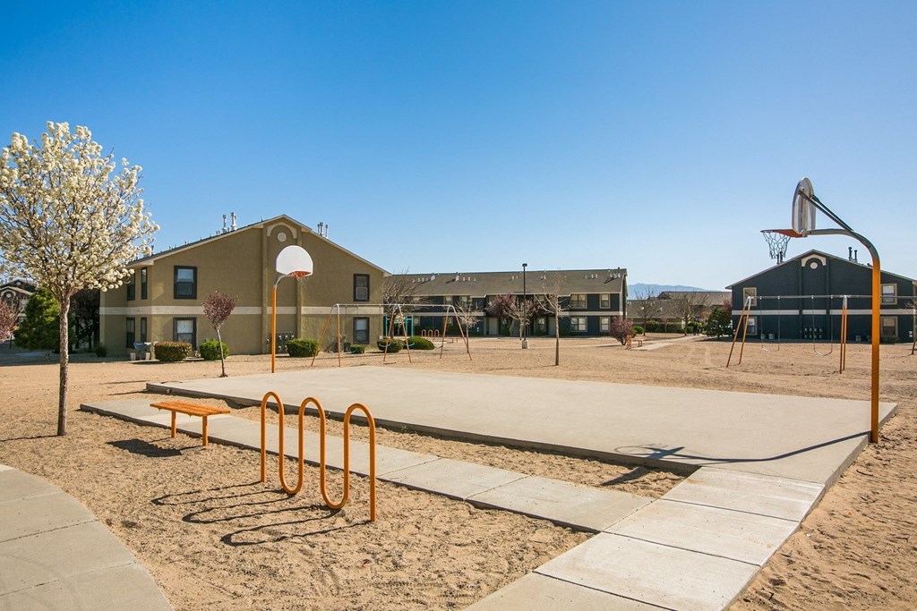 A basketball court with a basketball hoop and a building in the background.