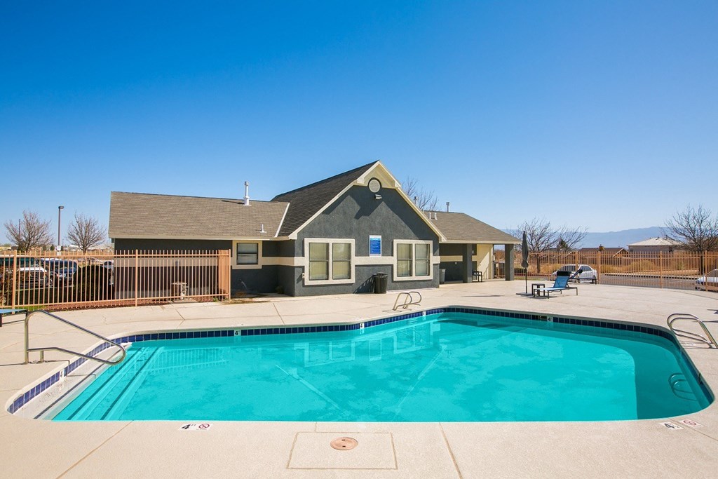 A swimming pool in front of a house.
