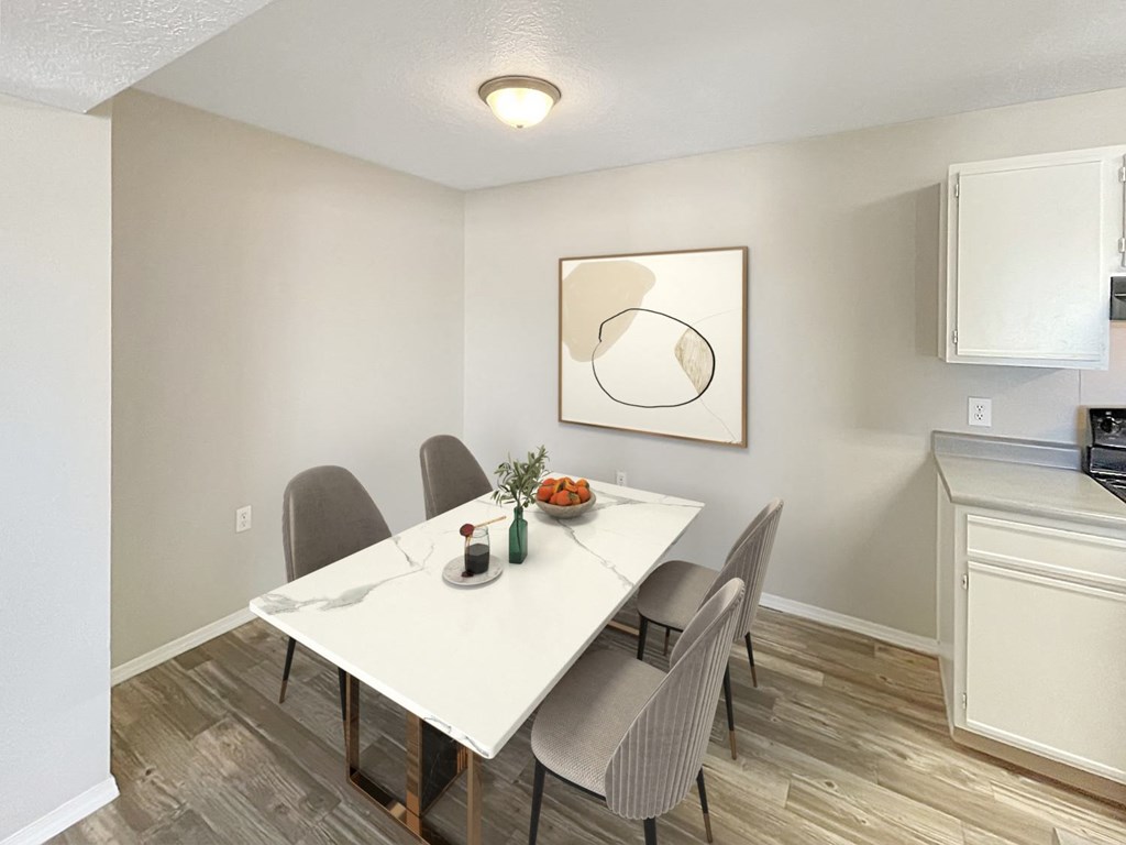 A dining room with a white table and chairs.