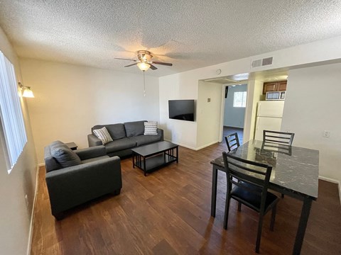 A living room with a grey couch and a black chair.