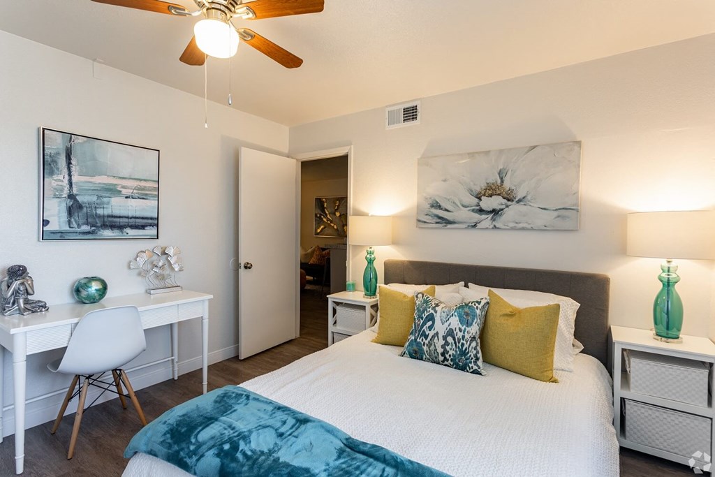 A bedroom with a bed, desk, and chair.