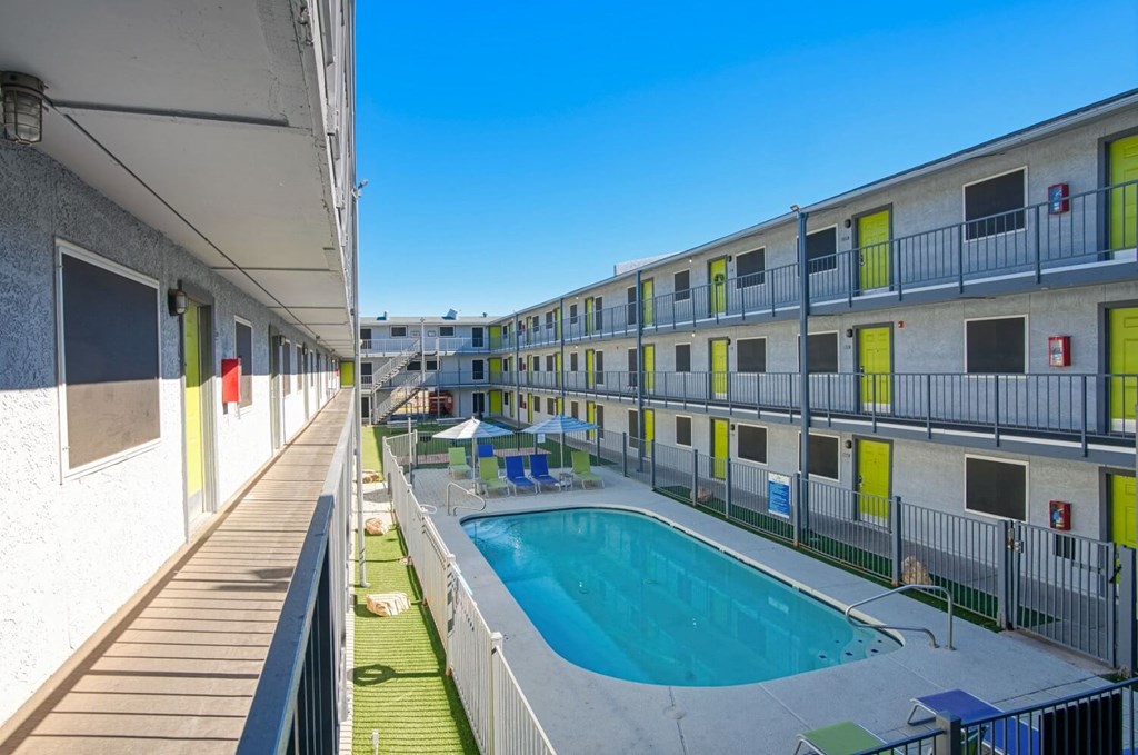 A pool is surrounded by apartment buildings.