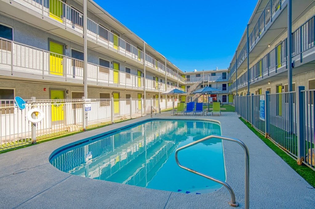 A swimming pool is surrounded by apartment buildings.