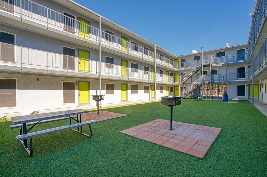 A courtyard with a bench and a table in the middle.
