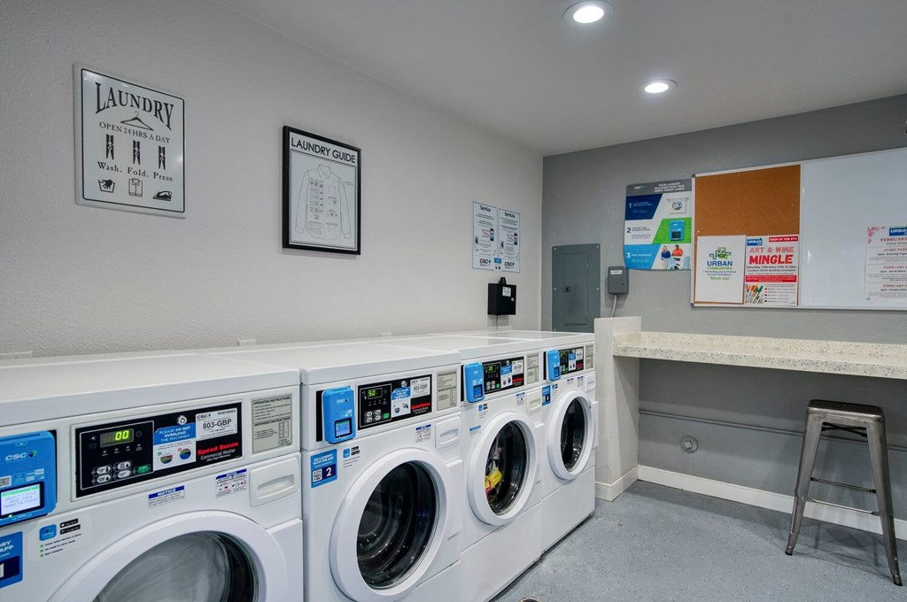 A laundry room with washing machines and a laundry sign on the wall.