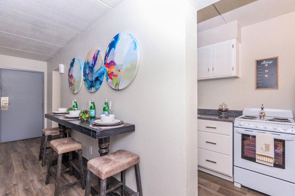 A kitchen with a table and chairs and a white oven.