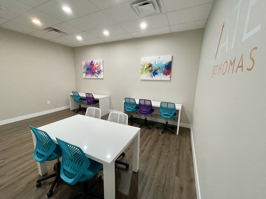 A conference room with a white table and blue chairs.