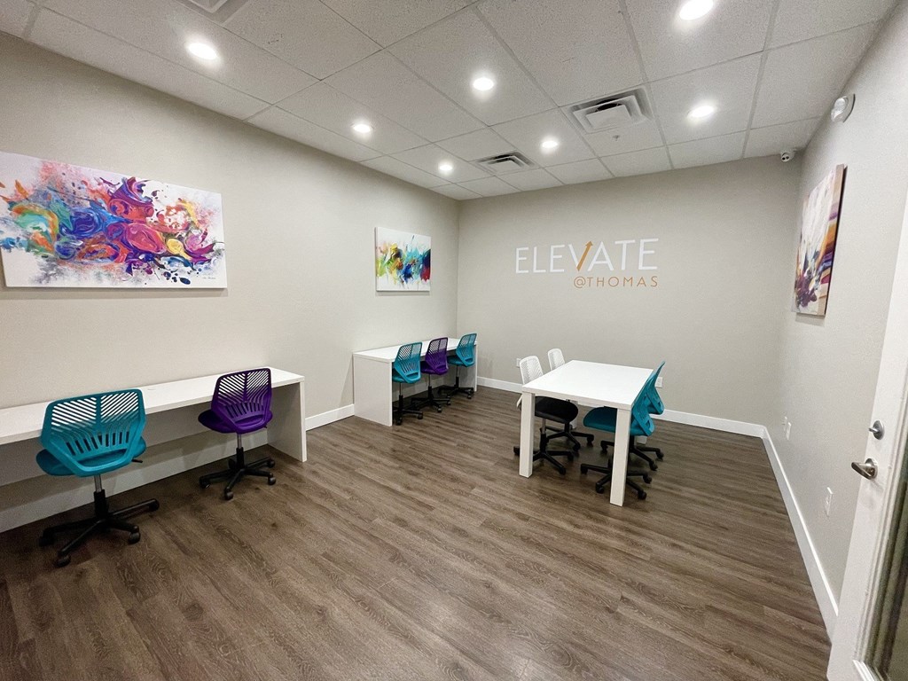 A conference room with a white table and chairs.