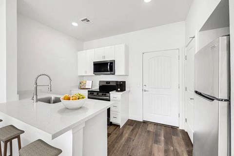 A modern kitchen with white cabinets and appliances.