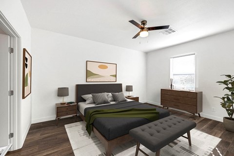 A bedroom with a bed, nightstand, and a plant.