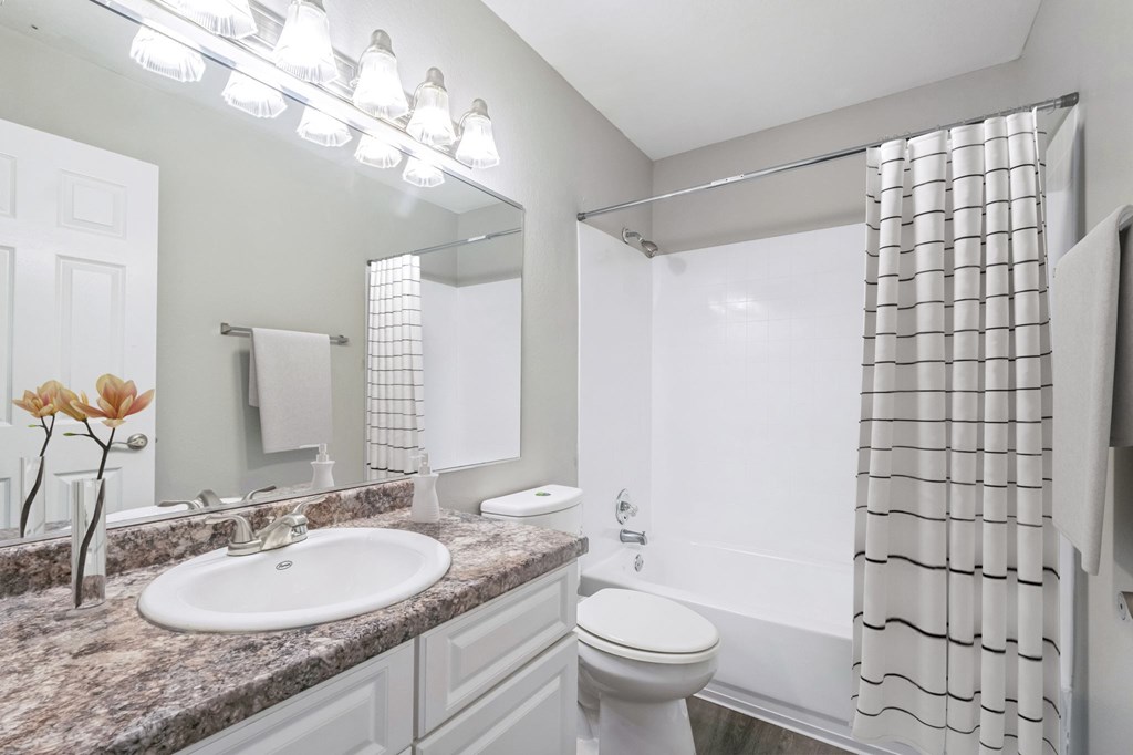 A bathroom with a sink, toilet, and shower.