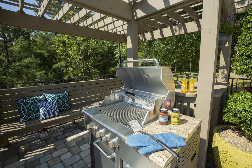A grill is on a patio with a blue towel on it.