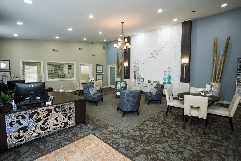 A reception area with a desk, chairs, and a patterned carpet.