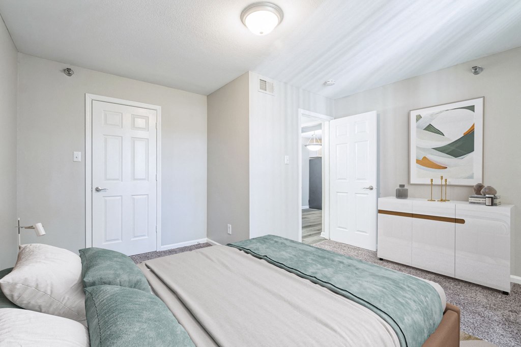 A bedroom with a large bed and a painting on the wall.