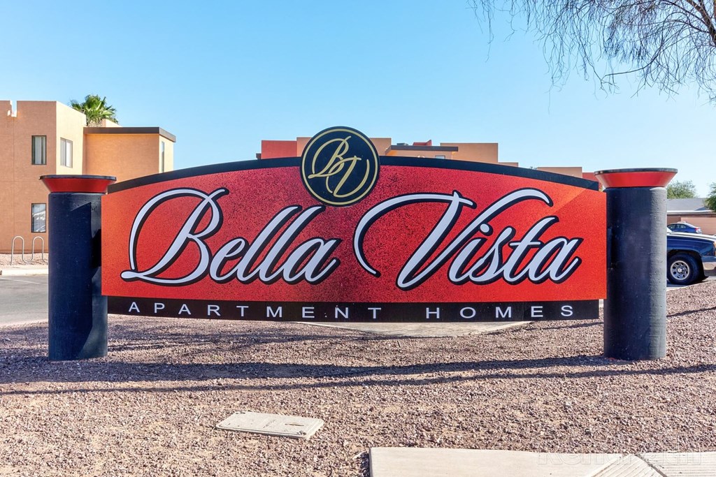 A sign for Bella Vista Apartment Homes is displayed in front of a building.