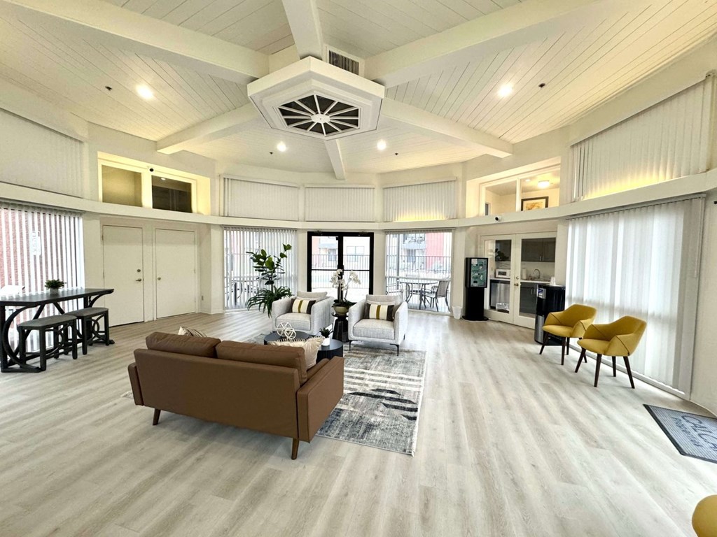 A spacious living room with a brown sofa and a yellow chair.